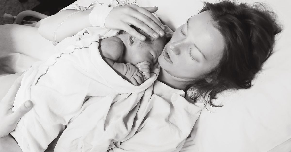 День матери в больнице. Женщина с младенцем на руках. Новорожденный после родов. Женщина с новорожденным ребенком на руках.