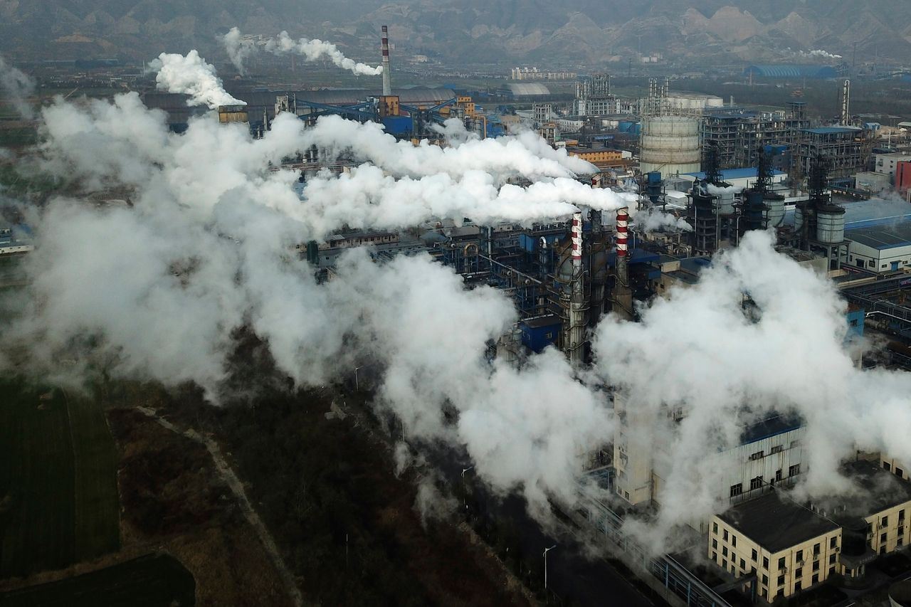 In this November 2019, photo, smoke and steam rise from a coal processing plant in central China's Shanxi Province