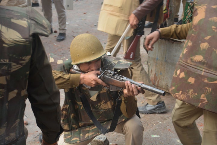 A police personnel aims his gun towards protesters during demonstrations against India's new citizenship law in Meerut on December 20, 2019. - Five more protesters died in fresh clashes on December 20 between Indian police and demonstrators, taking the death toll to 14 from more than a week of unrest triggered by a citizenship law seen as anti-Muslim, as thousands rallied at the nation's biggest mosque. (Photo by STR / AFP) (Photo by STR/AFP via Getty Images)