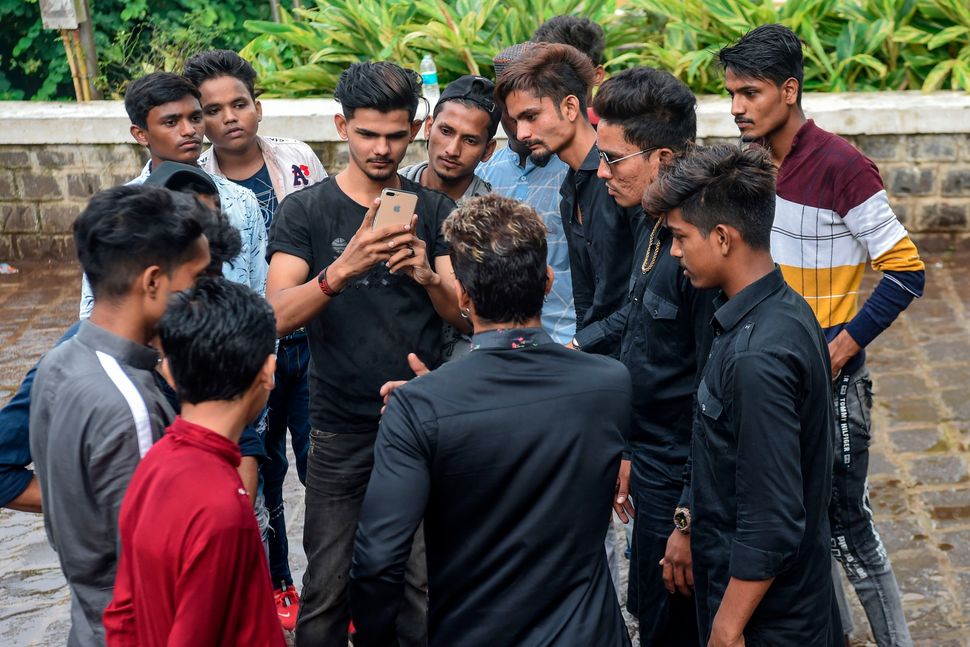 In this photo taken on November 10, 2019, youngsters gather around mentor Akhtar Shaikh (back to camera) before a video-recording session in Mumbai. Image used for representational purposes only in this article.