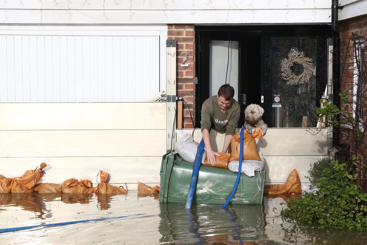 A man attempts to pump water out of his home in Yalding, Kent, after the area flooded.