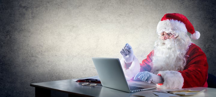Santa Claus With Laptop Sitting On Desktop