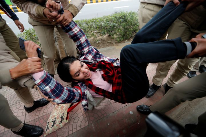 Police detain a woman protester in front of Uttar Pradesh Bhawan in New Delhi on Monday.