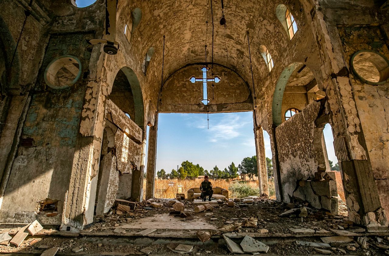 A member of the Khabour Guards (MNK) Assyrian Syrian militia, affiliated with the Syrian Democratic Forces (SDF), sits in the ruins of the Assyrian Church of the Virgin Mary, which was previously destroyed by Islamic State (IS)
