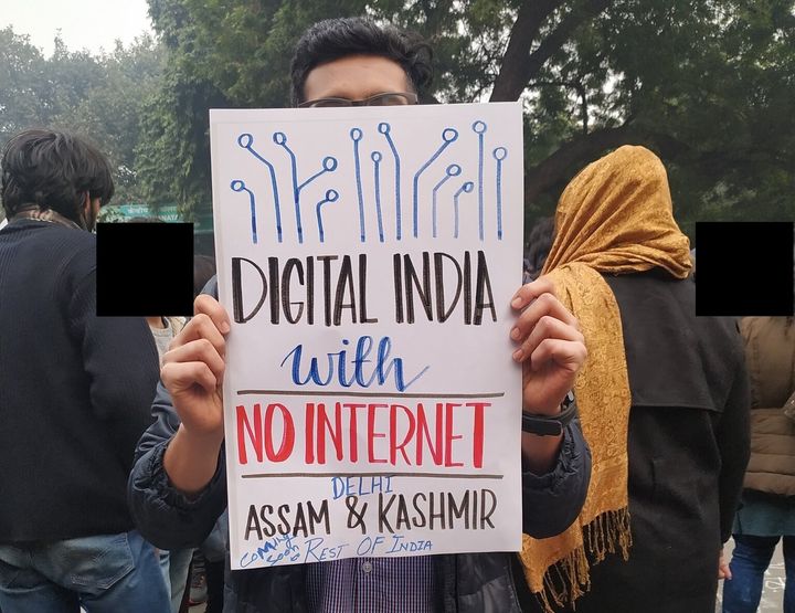 A protester holding up a sign about Internet shutdowns in India.