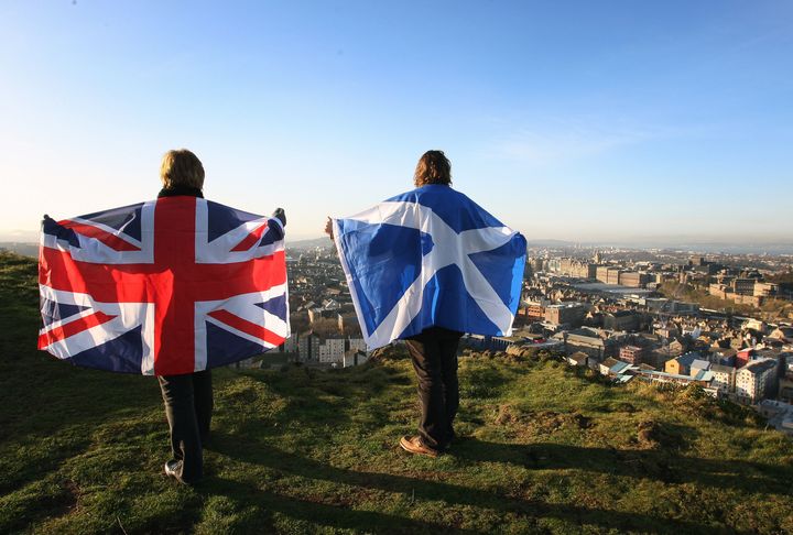 Scottish and British flags held up over Edinburgh, Scotland