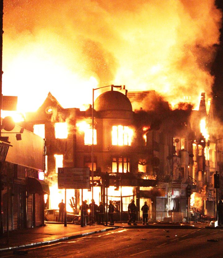 A property on fire near Reeves Corner, Croydon, south London, during a third night of unrest in the capital, with trouble flaring up in other English cities.