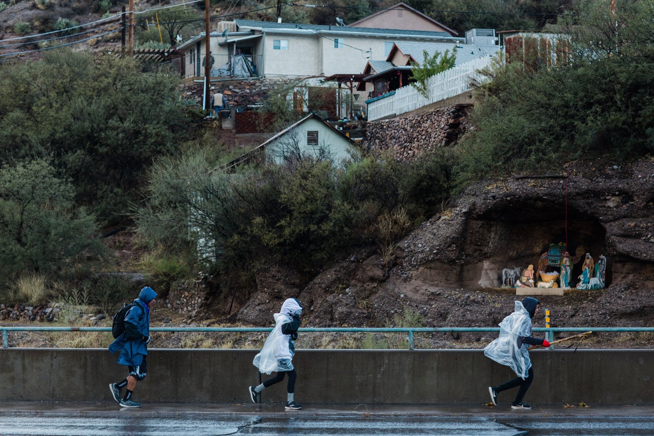 Taylor Thorne, 15, Báásé Pike, 15, and Wendsler Nosie Sr. run past a nativity scene on Nov. 29 near the Old Dominion Historic Mine Park in Globe, Arizona.