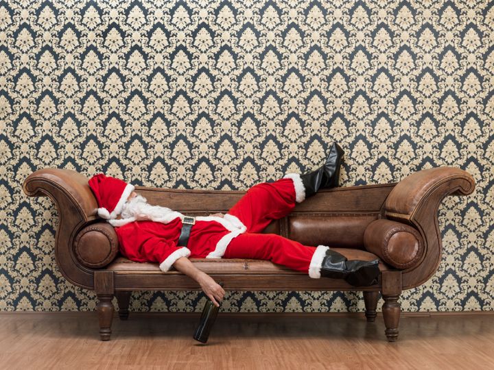 Drunk Santa Claus lying on sofa