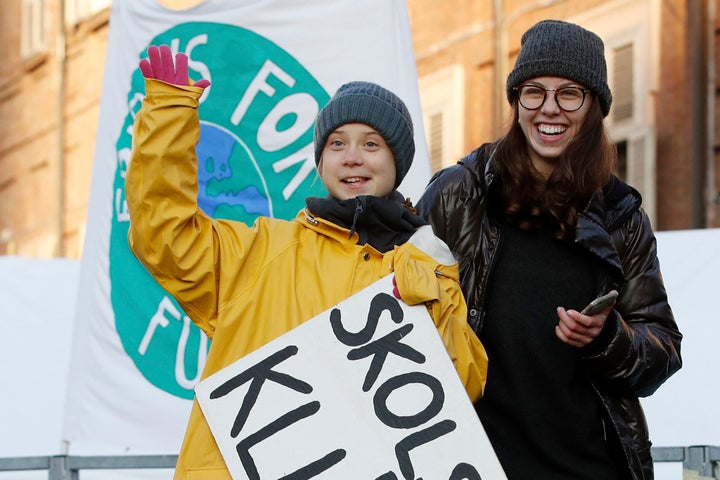 Greta Thunberg holds a sign with writing in Swedish that says, "School strike for the climate" as she attends a climate march