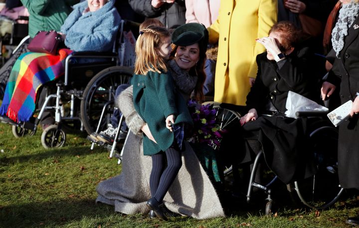 The Duchess of Cambridge puts her arm around Charlotte as they greet people after church. 