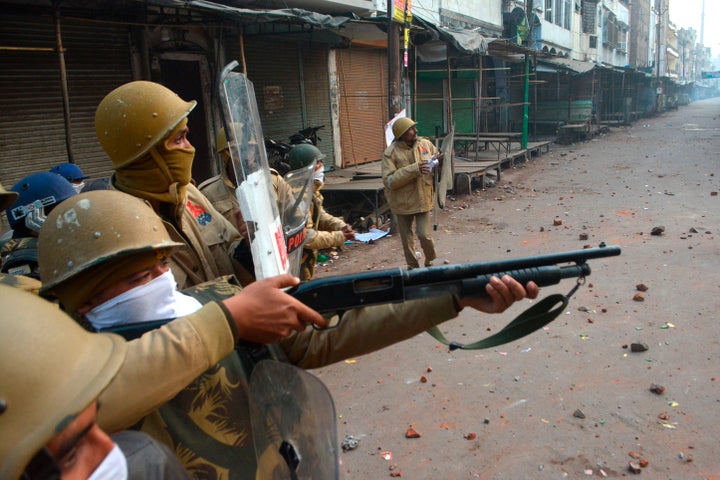 A police personnel aims his gun towards protesters during demonstrations against India's new citizenship law in Kanpur on December 21, 2019. - Thousands of people joined fresh rallies against a contentious citizenship law in India on December 21, with 20 killed so far in the unrest. (Photo by STR / AFP) (Photo by STR/AFP via Getty Images)