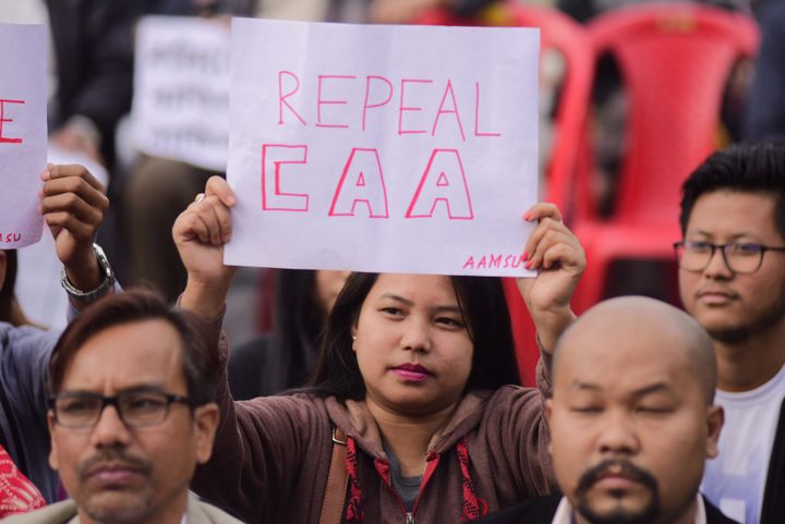 A woman holds a playcard during a protest against the Citizenship Amendment Act in Guwahati.
