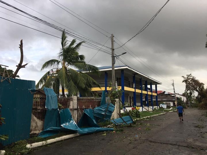A man walks past damaged homes after Typhoon Phanfone swept through Tanauan, Leyte