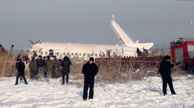 Police stand guard as rescuers assist on the site of a plane crash near Almaty International Airport, outside Almaty, Kazakhstan, Friday, Dec. 27.