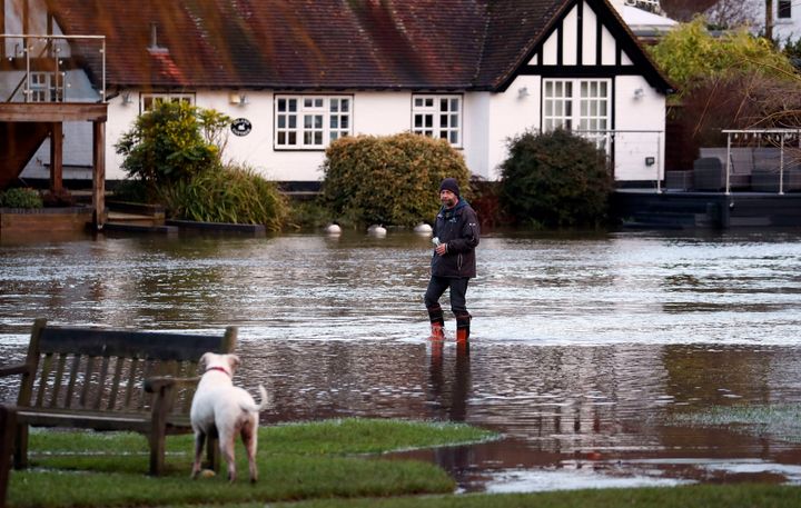 Walkers wade along a flooded towpath in Henley-on-Thames, England, Thursday, Dec. 26, 2019. (Steve Parsons/PA via AP)