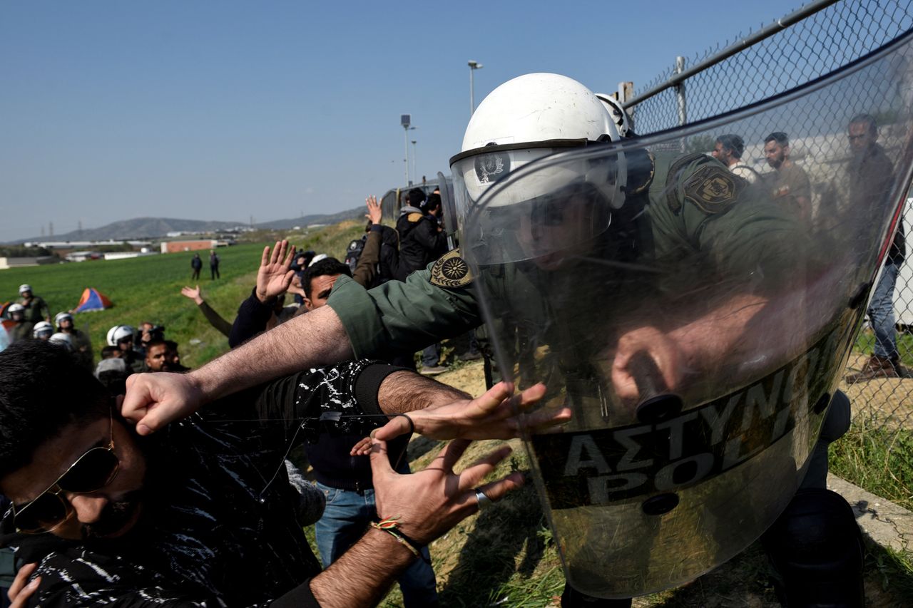 Ένας αστυνομικός χτυπά έναν μετανάστη, σε ταραχές στα Διαβατά στη βόρεια Ελλάδα, 4 Απριλίου 2019.