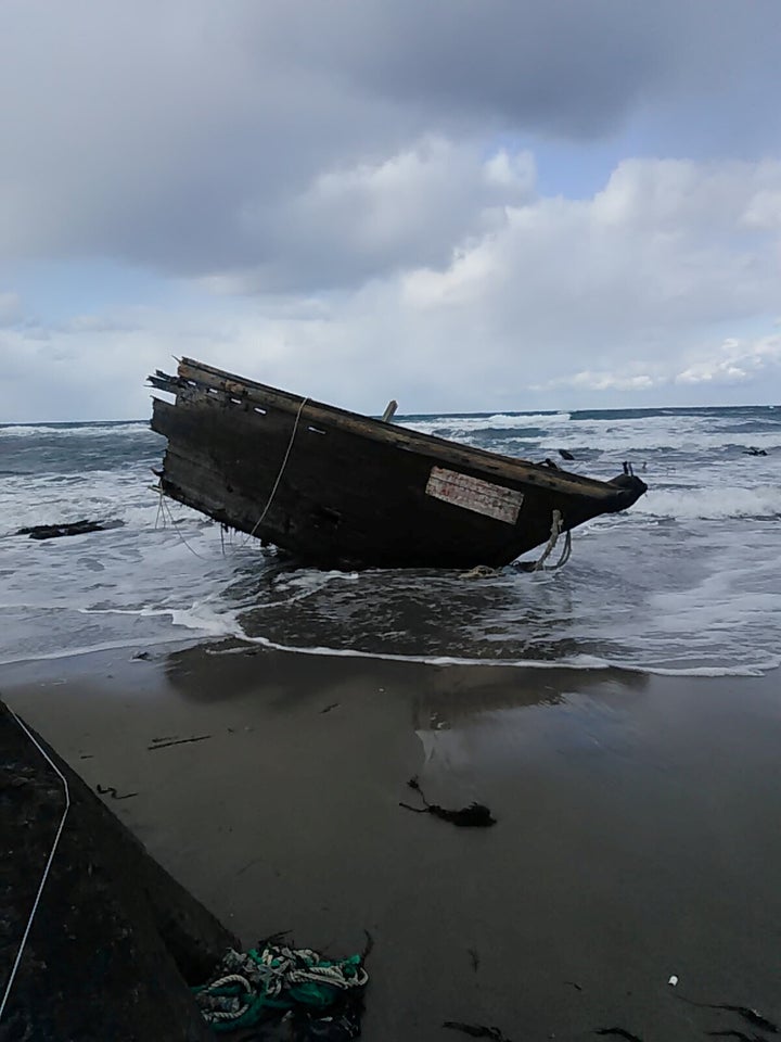 Part of a wooden boat containing human remains and suspected to be from North Korea is seen along a shore of Sado island, Nii