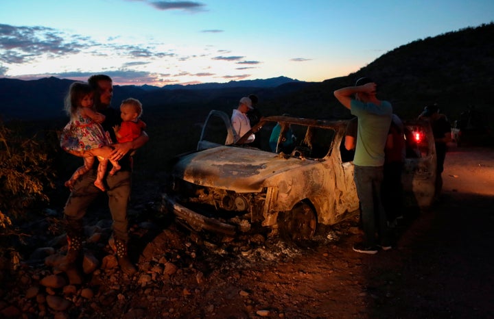 Members of the LeBaron family inspect a burned car where the bodies of nine of their family members were found after an ambush in Sonora, Mexico, on Nov. 4, 2019.