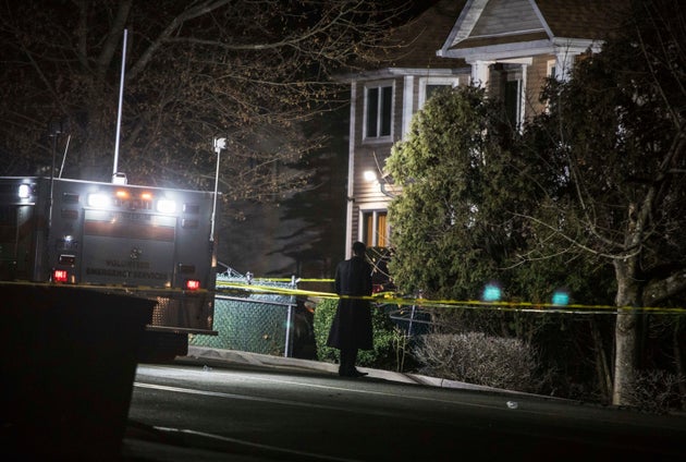 An Orthodox Jewish man stands in front of a residence in Monsey, New York, following a stabbing late Saturday during a Hanukkah celebration.