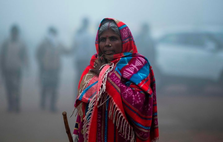 A woman walks along a street under heavy foggy conditions in New Delhi on December 30, 2019. (Photo by Jewel SAMAD / AFP) (Photo by JEWEL SAMAD/AFP via Getty Images)