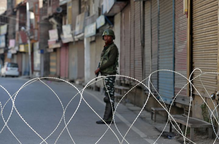 A security force personnel stands guard in front of closed shops during restrictions following abrogation of Article 370, in Srinagar, September 10, 2019.