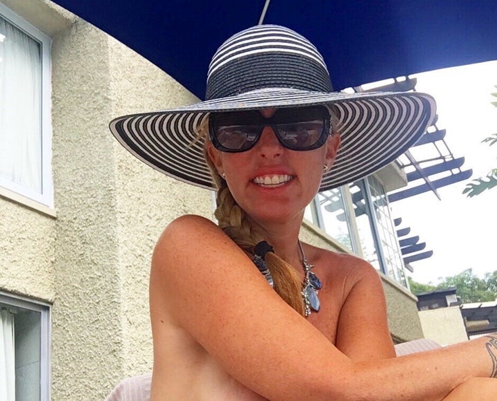 Jenny Block wearing just a hat and a necklace while enjoying the sun at a nudist swingers resort.