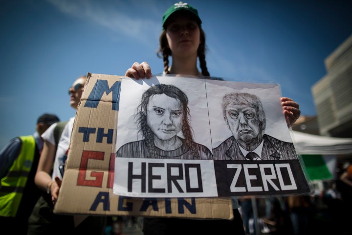 A woman holds a placard depicting Greta Thunberg and President Donald Trump during a climate change demonstration in Rome, Italy, back in April.