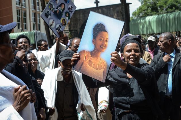 Mourners carry portraits of victims of the crashed accident of Ethiopian Airlines during the mass funeral...