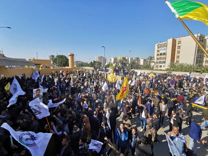 Protesters and militia fighters gather outside the main gate of the US embassy in Baghdad, Iraq, on December 31