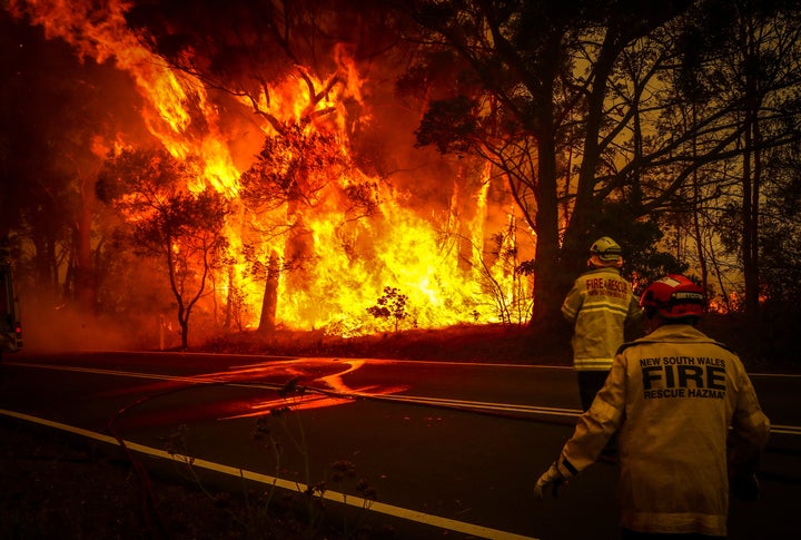 Fire and rescue personnel watch a bushfire as it burns near homes on the outskirts of the town of Bilpin on Dec. 19, 2019.