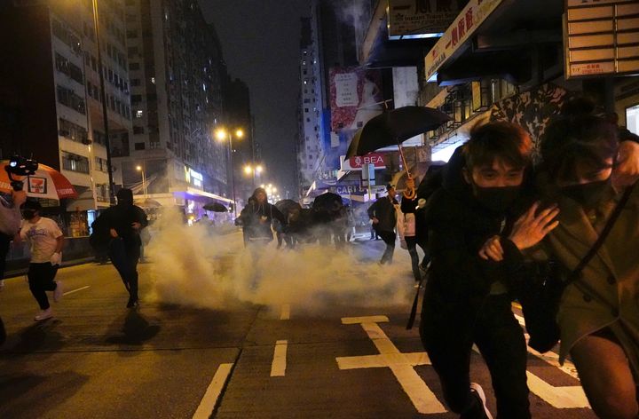 Protesters react as police fire tear gas during a demonstration in Hong Kong.