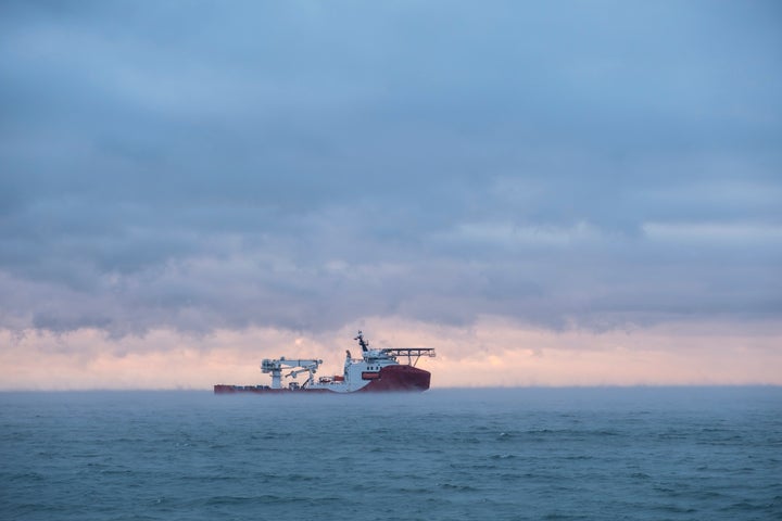 Ship loading pipeline into the sea. Beautiful sea view at sunset