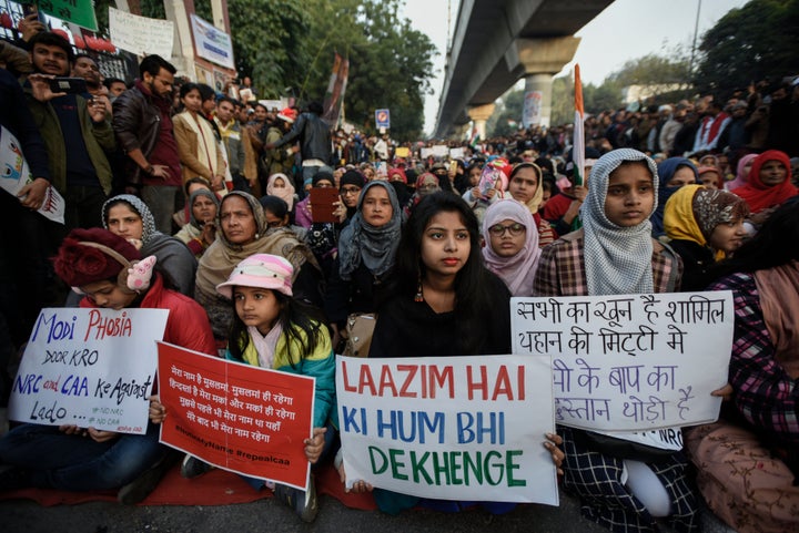 NEW DELHI, INDIA - DECEMBER 25: People hold placards as they take part in a protest on the 11th straight day, against the Citizenship Amendment Act (CAA) and National Register of Citizens (NRC) at Jamia Millia Islamia on December 25, 2019 in New Delhi, India. (Photo by Burhaan Kinu/Hindustan Times via Getty Images)