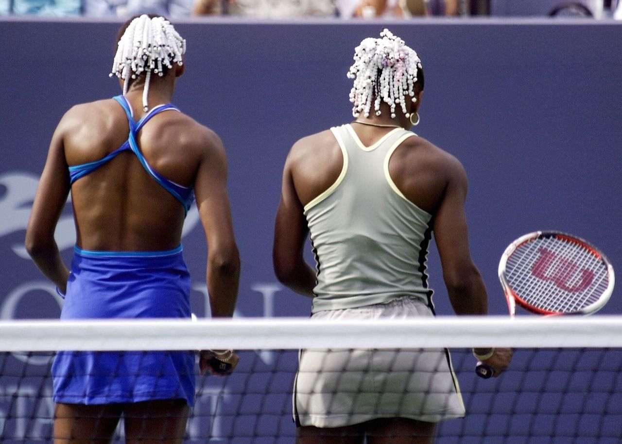 Venus (left) and Serena Wiliams talk strategy during a match at the U.S. Open in Flushing Meadows, New York, on Sept. 2, 1999.