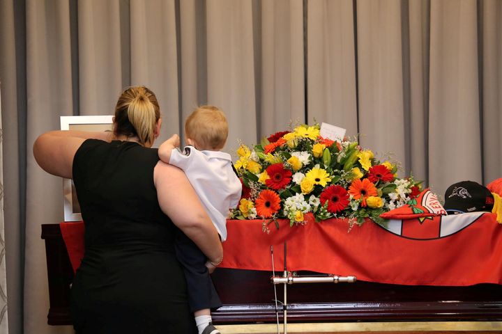 Keaton's partner and son at his funeral on Thursday 