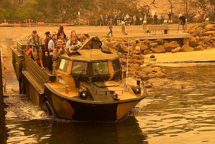 In this photo released and taken Jan. 2, 2020, by the Australian Department of Defense, evacuees are transported in a lighter, amphibious, resupply, cargo (LARC) transport amphibious vehicle, from Mallacoota, Victoria, Australia. Navy ships plucked hundreds of people from beaches and tens of thousands were urged to flee before hot weather and strong winds in the forecast worsen Australia's already-devastating wildfires. (Australia Department of Defense via AP)