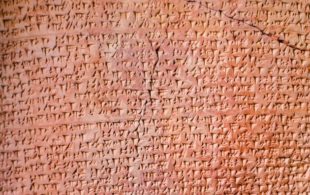 ancient Assyrian clay tablet document covered by cuneiform
