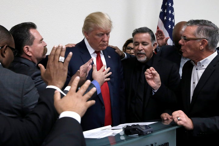 Donald Trump prays with pastors during a 2016 election campaign visit to the International Church of Las Vegas in Las Vegas,