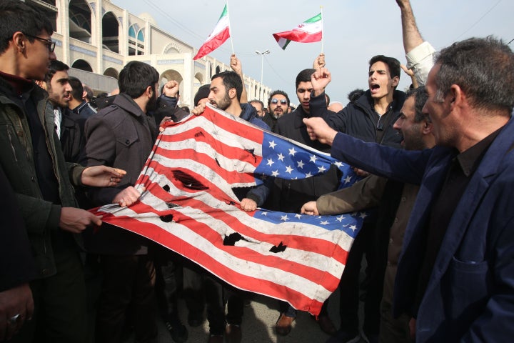 Iranians tear up an American flag during the protests.