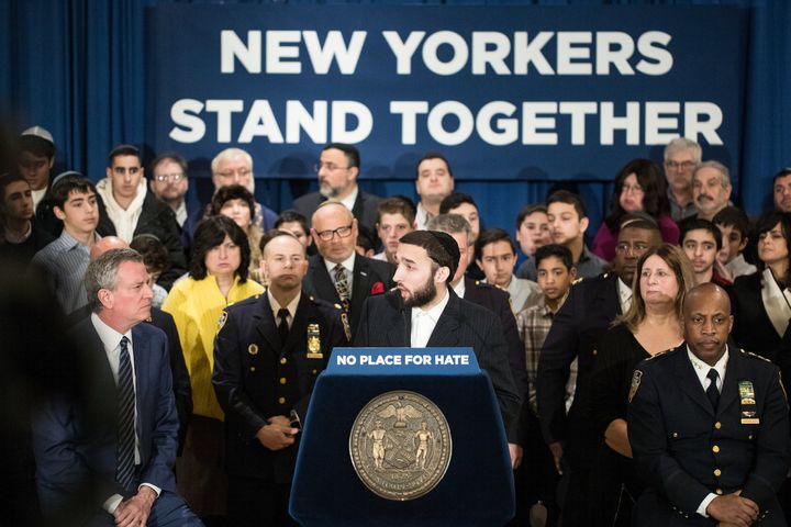 New York Assemblyman Simcha Eichenstein (D) delivers remarks at a rally against anti-Semitism in Brooklyn in February 2019. New York City Mayor Bill de Blasio, left, looks on.