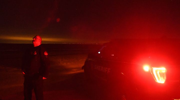 Lincoln County Sheriff's Deputy Justin Allen stands outside of his squad car looking at the night sky near Limon, Colorado, on Jan. 2.