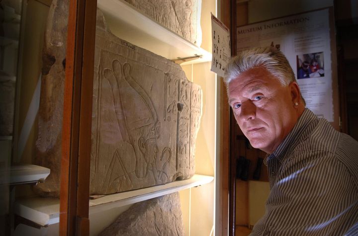 Medium and psychic Derek Acorah examines hieroglyphics on a stone tableau at the Petrie Museum of Egyptian Archaeology in central London.