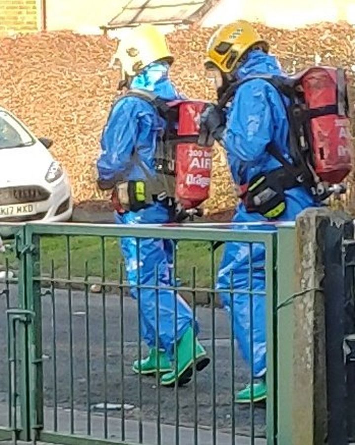 Handout photo taken with permission from the Twitter feed of @Jimh0791 of emergency services wearing protective clothing while attending the scene in Moor Lane.