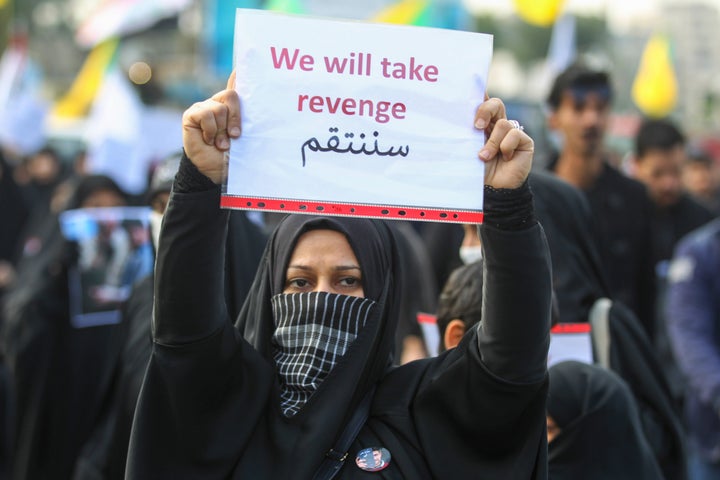 An Iraqi woman holds a placard during the funeral of Iranian military commander Qasem Soleimani.