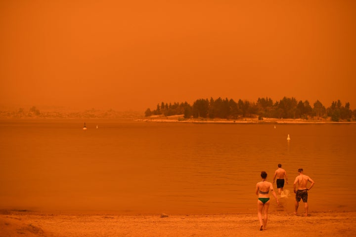 Residents take a dip to cool down at Lake Jindabyne, under a red sky due to smoke from bushfires, in the town of Jindabyne in New South Wales on Jan. 4. Up to 3,000 military reservists were called up to tackle Australia's relentless bushfire crisis, as tens of thousands of residents fled their homes amid catastrophic conditions.