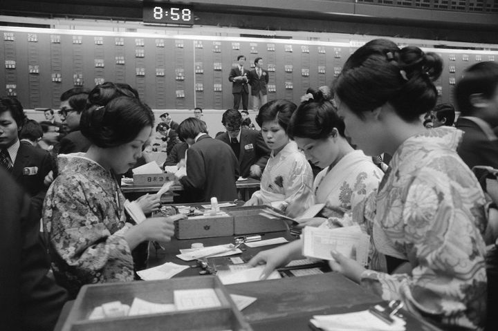 仕事始めで伝票の整理などをする和服姿の職員（東京・中央区の東京証券取引所）