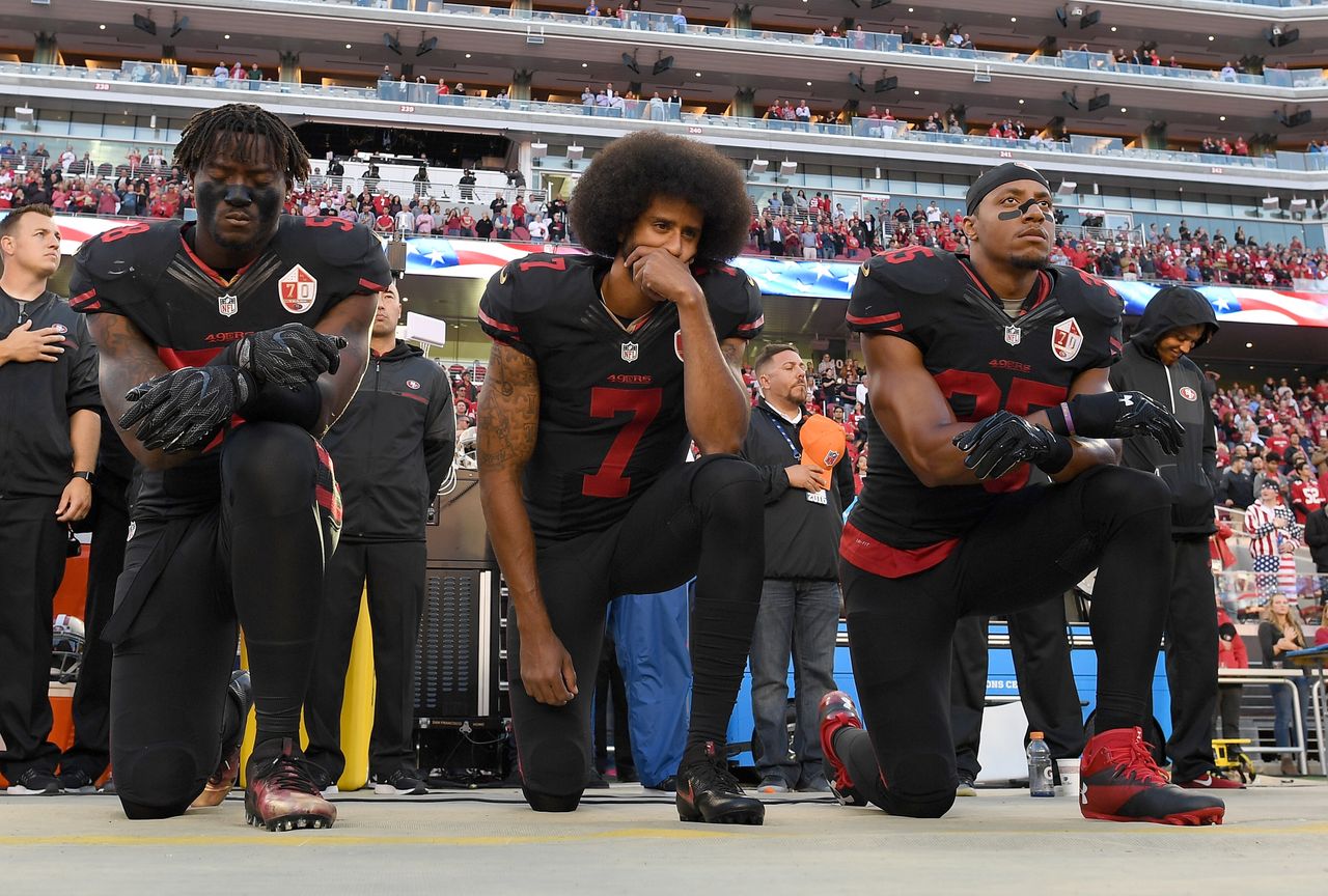 Teammates Eli Harold, Kaepernick and Eric Reid kneel in protest during the national anthem prior to a game against the Arizona Cardinals on Oct. 6, 2016.