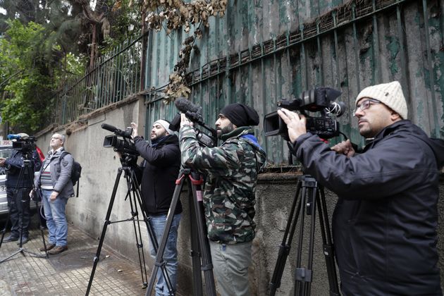 Des journalistes guettent devant une maison identifiée par des documents judiciaires comme appartenant...