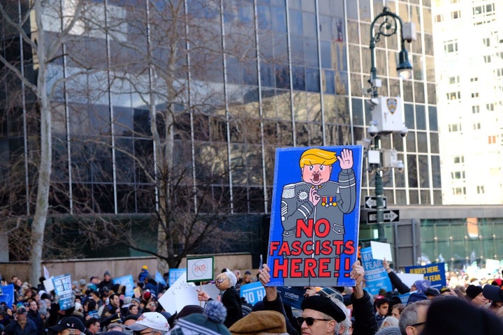 Marchers hold a sign depicting Trump as a fascist during the rally against anti-Semitism.